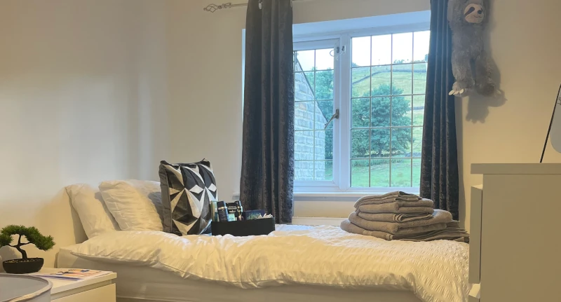 A bedroom with a view to the hills outside